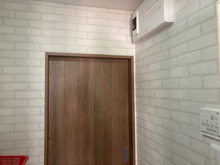 洗面所入口を片開ドアから上吊戸に変更して使いやすくし、分電盤はキッチン側から洗面所に移設しました。