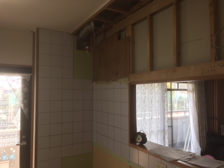 キッチン施工中<br />
キッチン解体後、お手入が楽なキッチンパネルをタイルの上に貼ります。