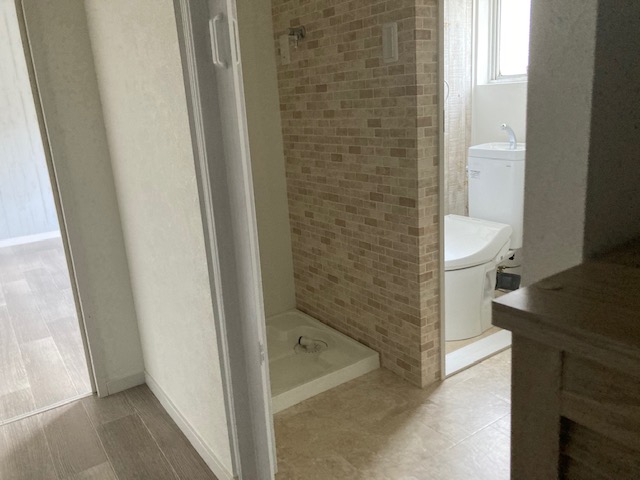 洗濯機置き場を新しく設けました。排水を浴室に流すため洗面所の床を10㎝ほどあげています。