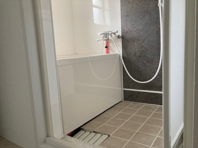 浴室施工後、壁、天井は浴室パネル、床はタイルで仕上げています。給湯器から新規でお湯の配管を新しく新設しました。