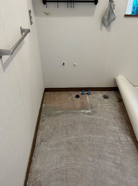 施工中<br />
洗面台を撤去後、クッションフロアを貼っていきます。