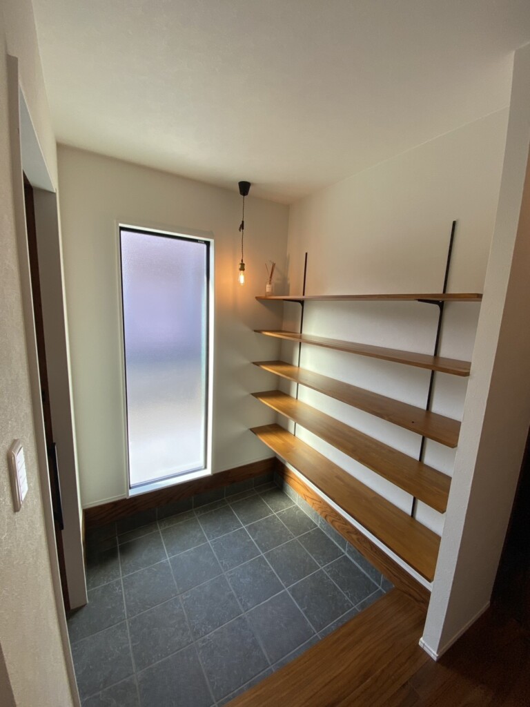 施工後の玄関です。<br />土間はタイルを貼ってきれいに、大きな窓とオープン棚を設置しました。